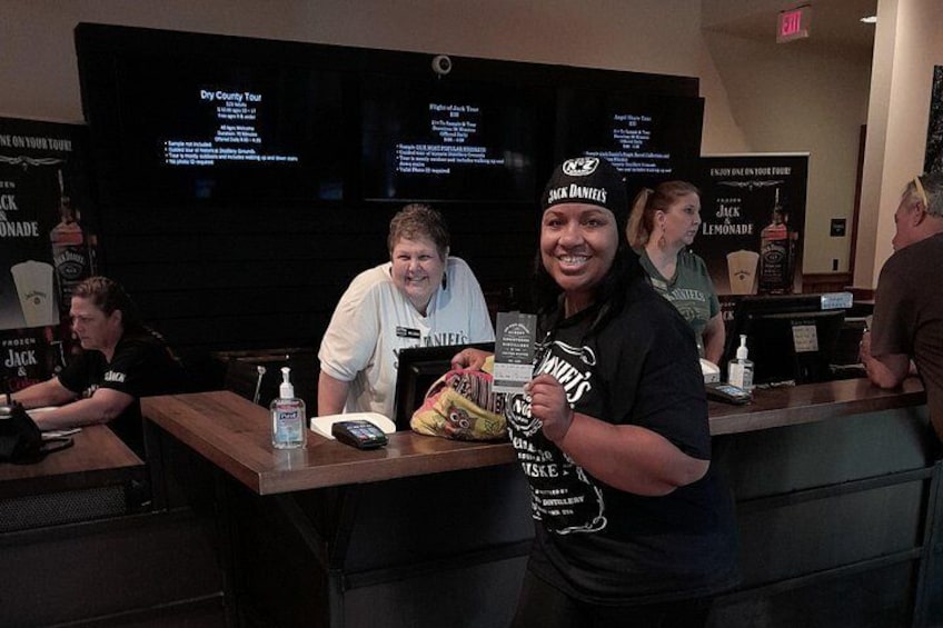 A person holding a bag of snacks at a counter with a menu board in the background. 5