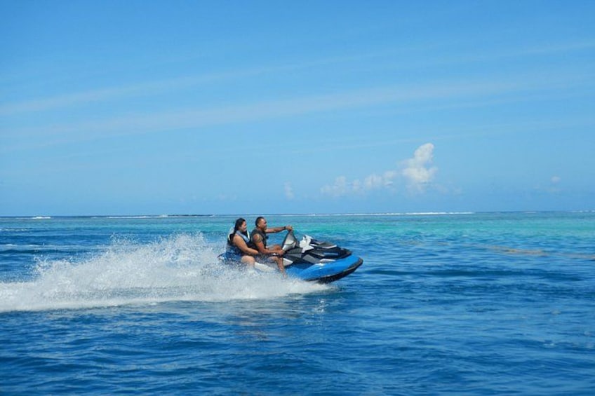Two people jet-skiing on a clear blue sea with a calm horizon. 3