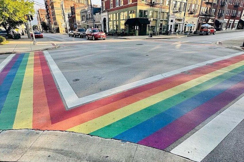 A street intersection with a rainbow-colored crosswalk. 1