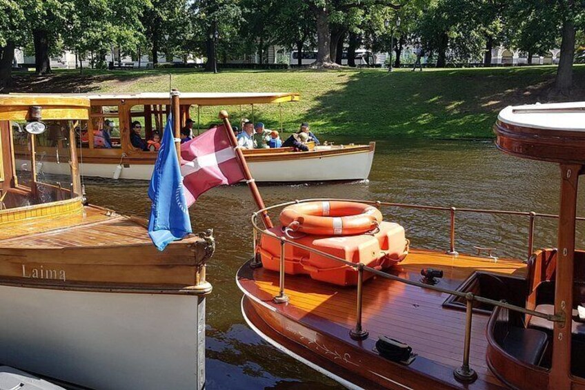 A wooden boat named 'Laima' docked at a pier with a lifebuoy and a blue flag. 2
