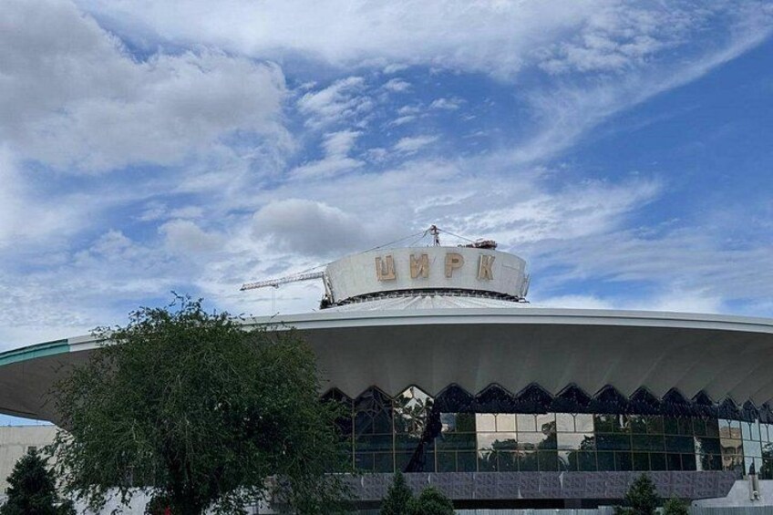 A large building with a curved roof and a crane on top. 3