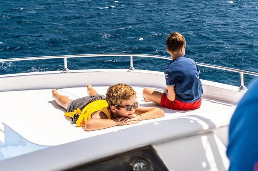 Two people on a boat, one lying down and the other sitting. 2
