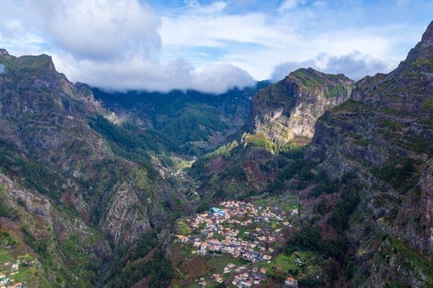 A mountainous landscape with a valley, a small town, and a river. 1