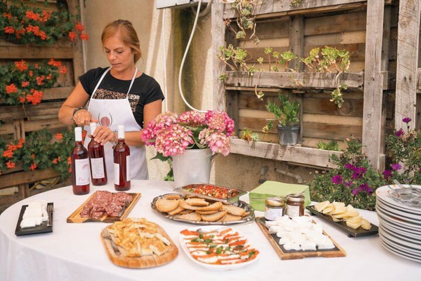 Une personne servant des plats lors d’un événement en plein air, devant une table remplie de différents mets et boissons. 4