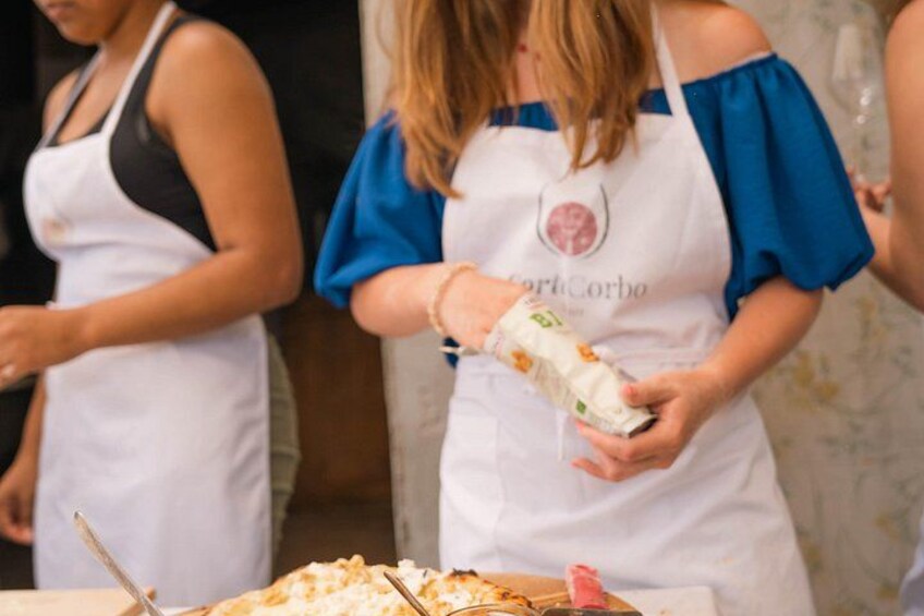 A person in a white apron with a logo, holding a wrapped item. 3