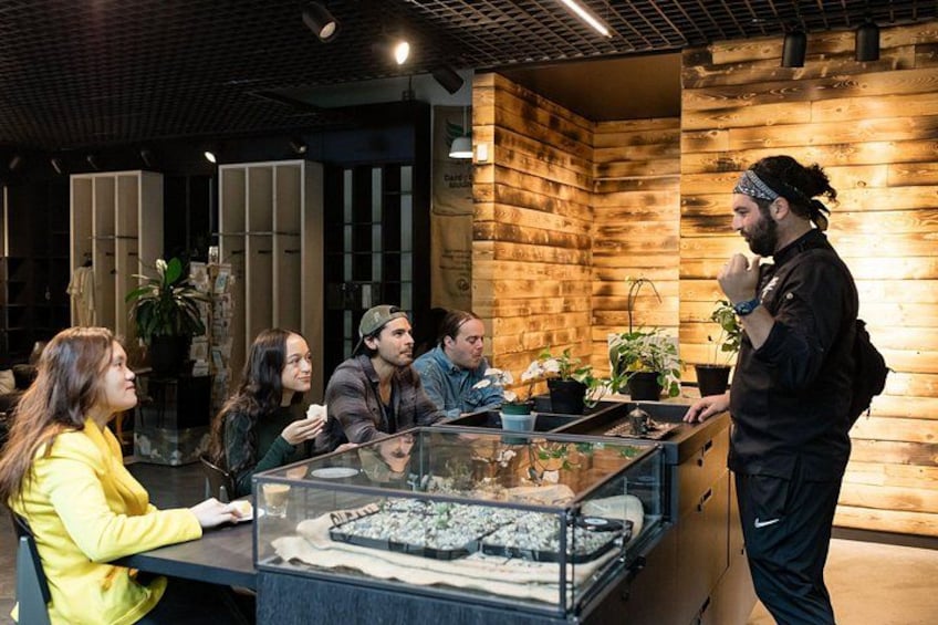 A group of people in a modern indoor setting with wooden walls and a glass display case containing items. 2