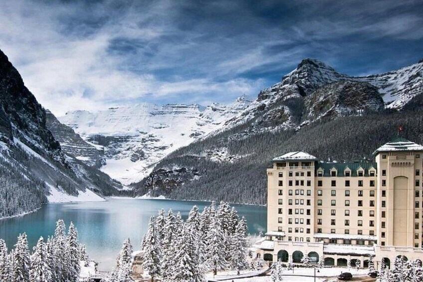 A snow-covered mountain landscape with a lake and a hotel building. 5