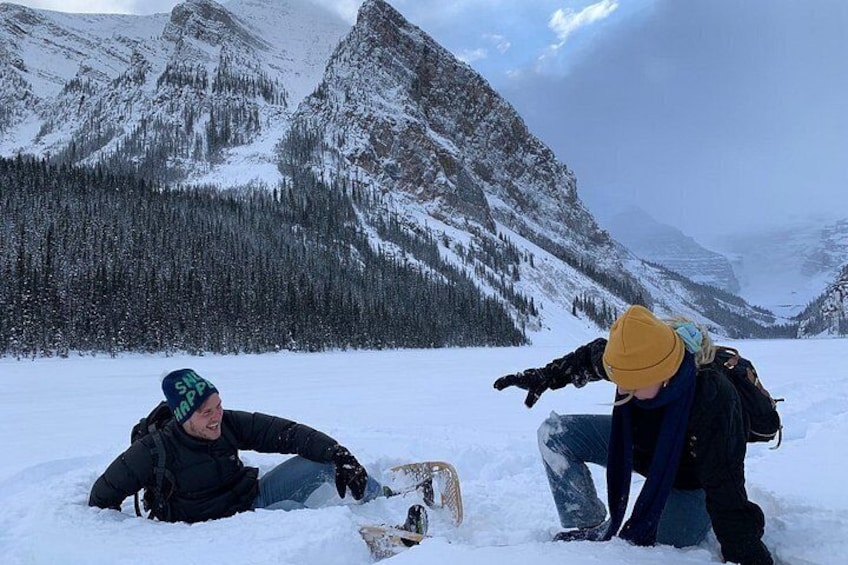 Two people in a snowy mountainous area with a snowboard. 3