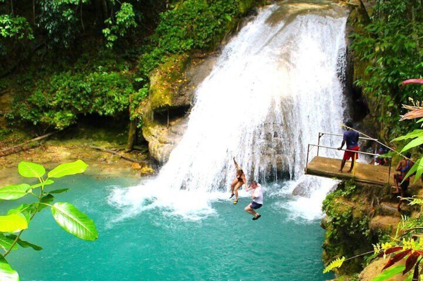 Een waterval met mensen die in het water springen. 1