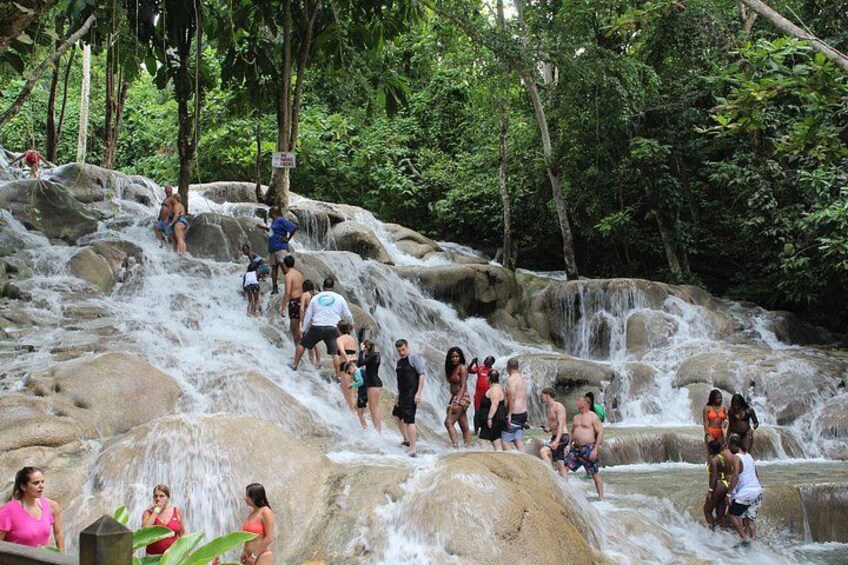Ein Wasserfall, an dem Menschen bergauf und bergab klettern. 2