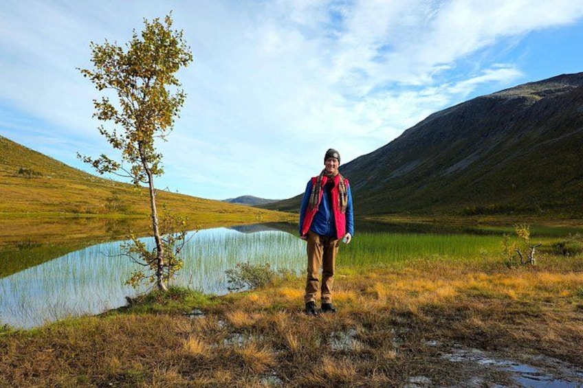 A person standing by a lake with a mountain in the background. 3