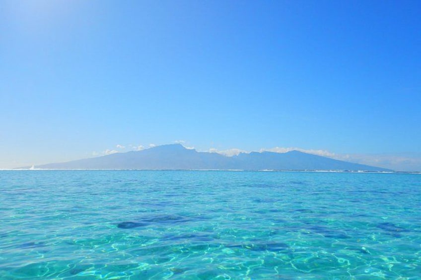 Un mare blu intenso con una catena montuosa in lontananza. 1