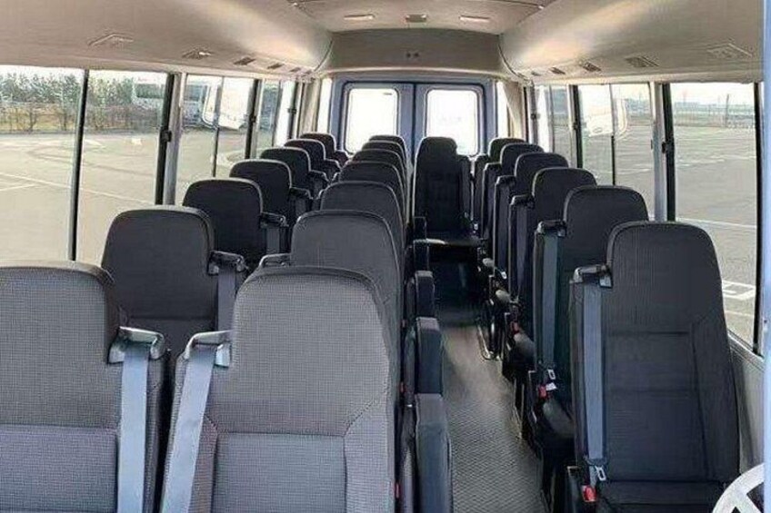L'intérieur d'un autobus, avec des rangées de sièges et une partie avant vitrée. 2