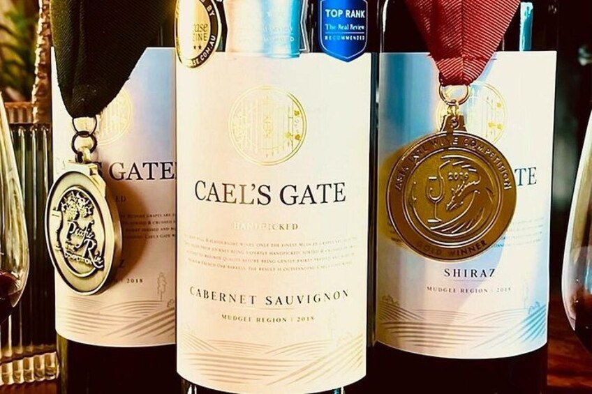 Tre flaskor vin, var och en med en medalj på etiketten. 2