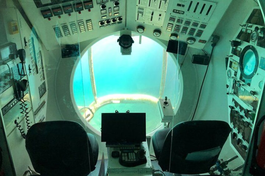 Ein Cockpit mit mehreren Bedienfeldern, einem großen Fenster und zwei Sitzen. 4