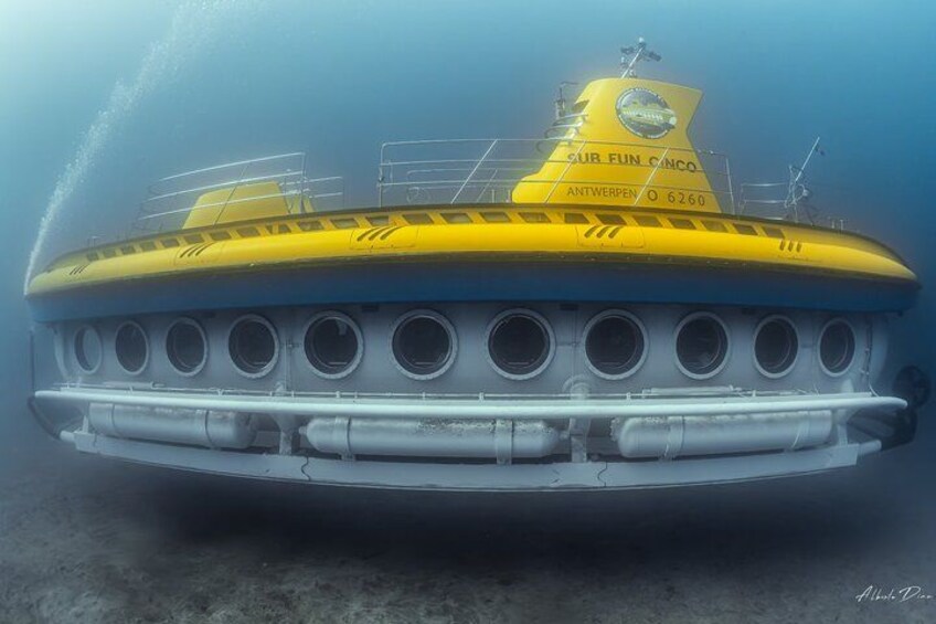 Ein gelbes U-Boot mit mehreren runden Fenstern und einem Namen an der Seite. 3