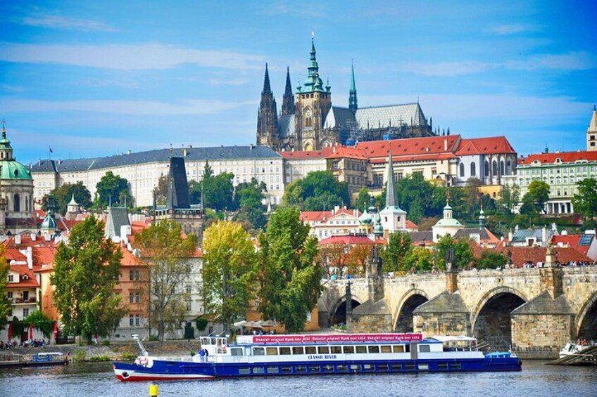 A river with a boat, a bridge, and historic buildings in the background. 1