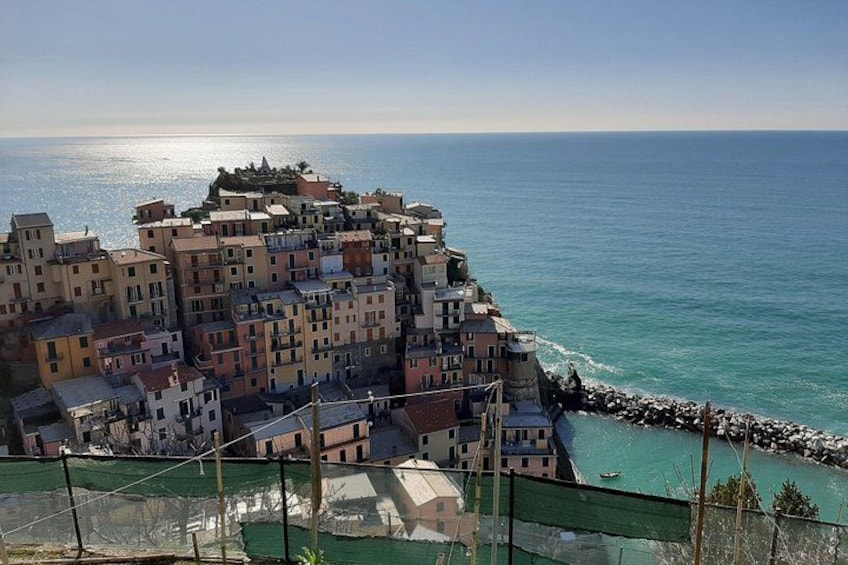 A coastal town with colorful buildings, a rocky shoreline, and the sea. 4