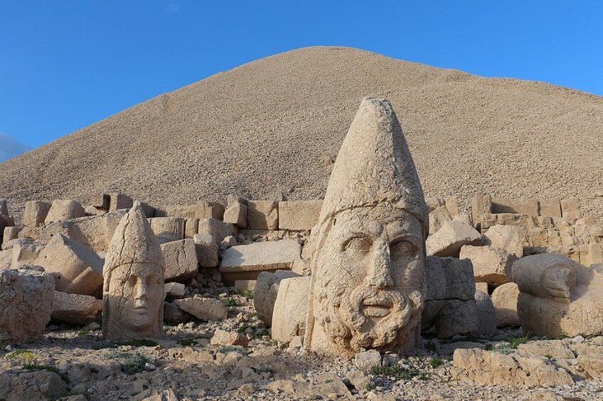 Ancient stone head sculptures in a desert landscape. 2