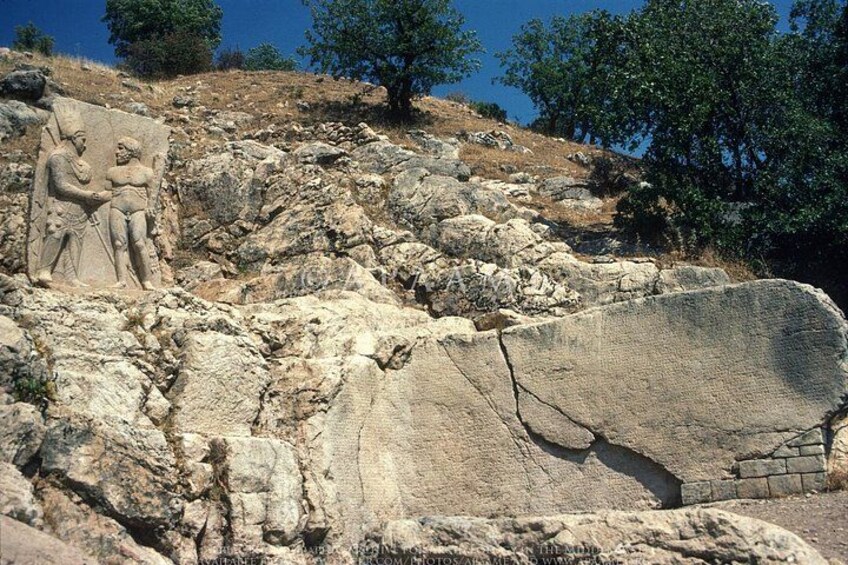 A rock with ancient carvings and a large stone slab. 3