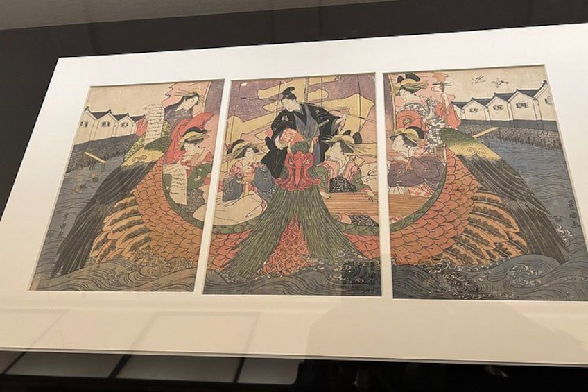 A framed triptych of a traditional Japanese artwork depicting a scene with a dragon boat and figures in traditional attire. 2