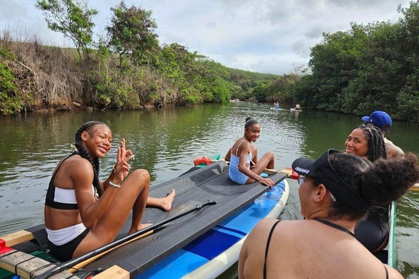 A group of people on a small boat in a river surrounded by greenery. 2