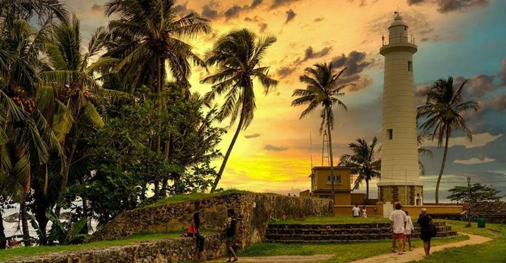 A lighthouse, palm trees, and a sunset. 2