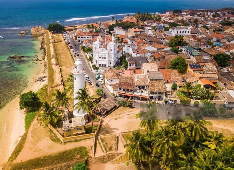 A coastal town with a prominent white lighthouse, a beach, and a mix of traditional and modern buildings. 1