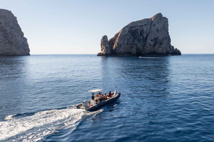 A boat on a calm sea with large rock formations in the background. 5
