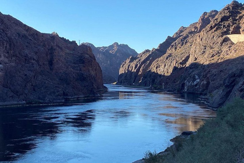A river canyon with steep rocky cliffs and a clear blue sky. 2
