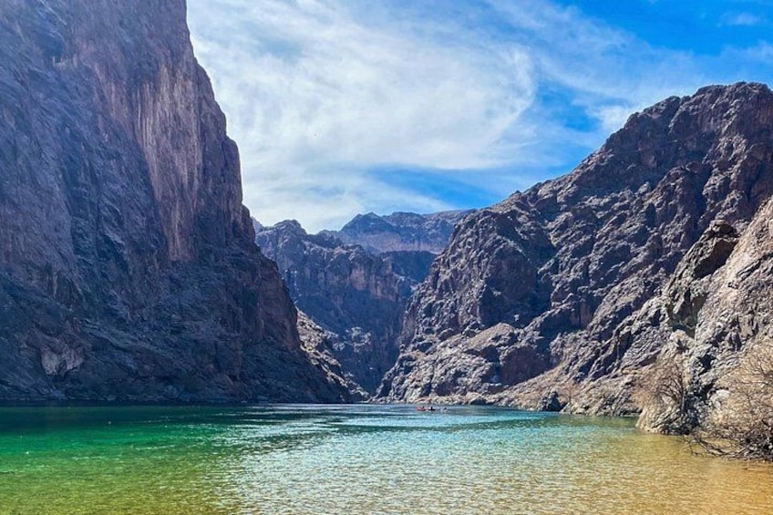 A canyon with a river, steep cliffs, and a clear sky. 3