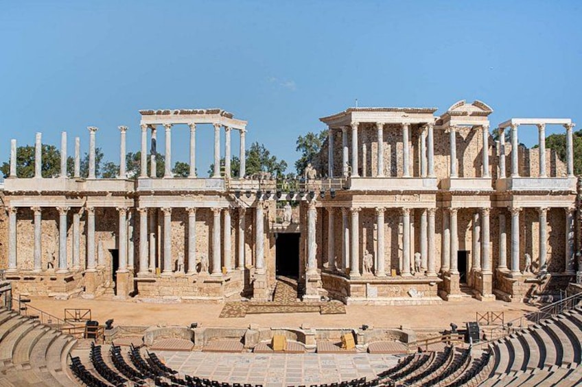 Ancient ruins with columns and a partially intact amphitheater. 1
