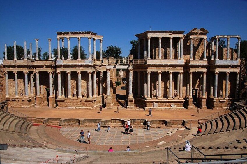 Ancient ruins with columns and a partially intact amphitheater. 2