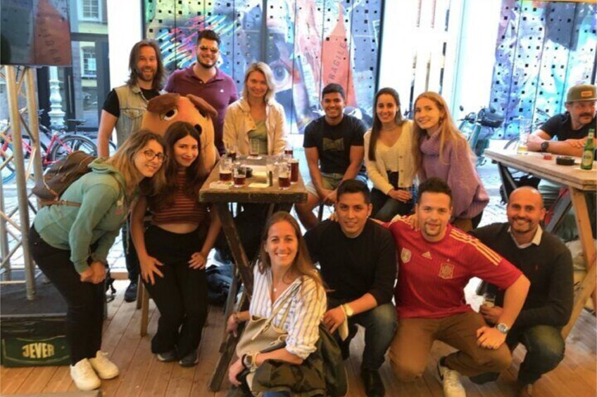 A group of people posing in a room with a table and chairs. 2