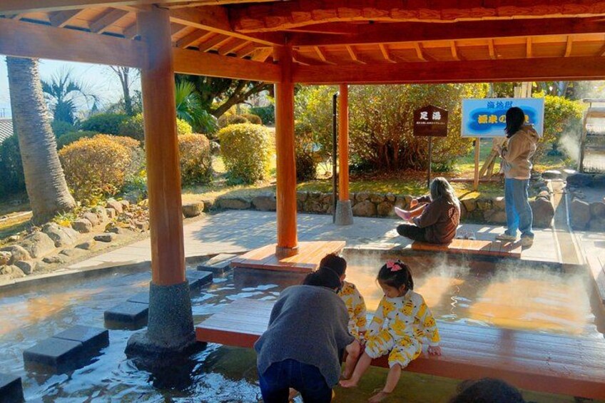A traditional Japanese onsen with people bathing in the hot spring, surrounded by stone lanterns and a wooden pavilion. 3
