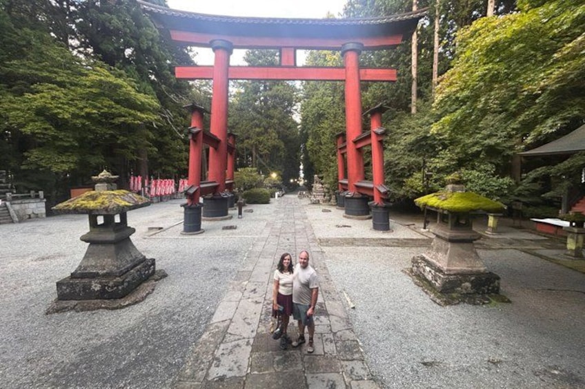 A traditional Japanese torii gate, stone lanterns, and a pathway leading to a shrine. 5