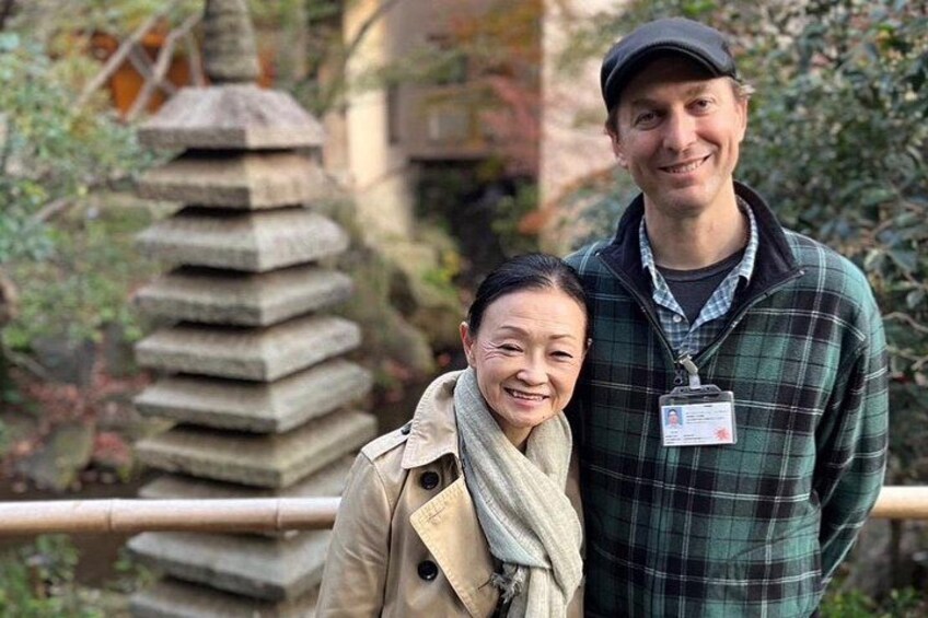 Two people standing near a stone structure with a metal railing. 4