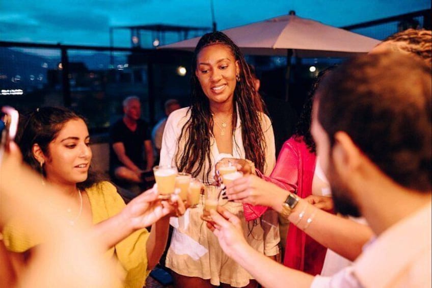 Un grupo de personas brindando con bebidas, de pie en el exterior de noche. 3
