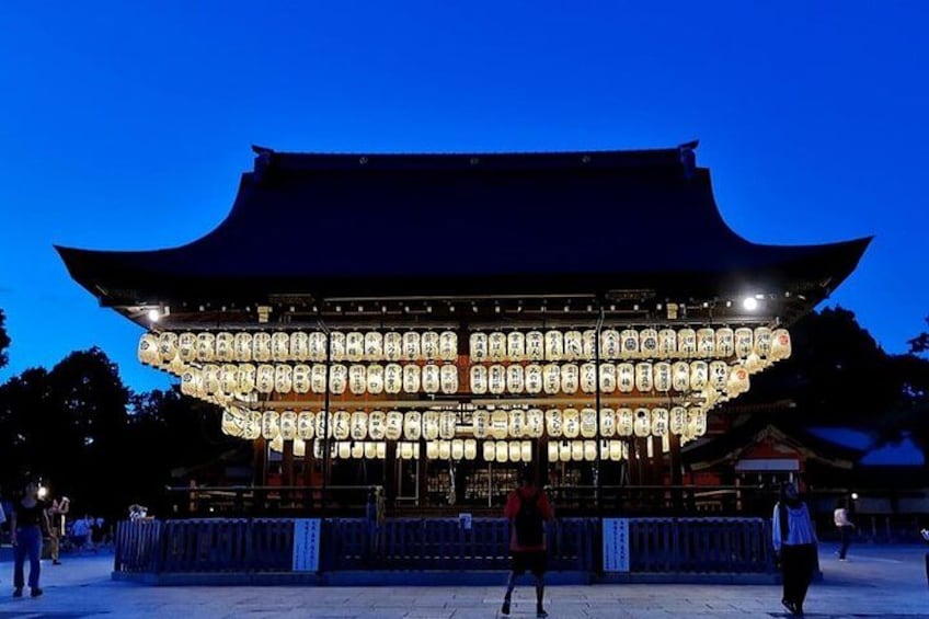 A traditional Japanese building with a curved roof and illuminated lanterns. 4