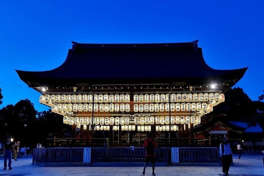 Un edificio tradicional japonés con techo curvo y faroles iluminados. 4