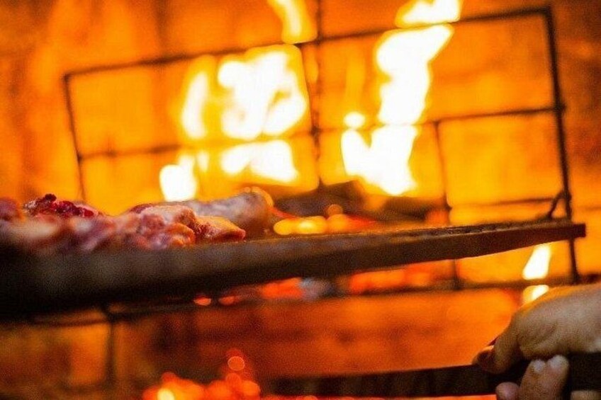 A grill with meat being cooked over an open flame. 1