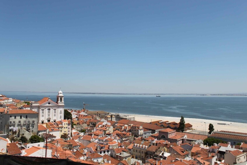 En kystby med røde tage, en markant kirke og en strand i baggrunden. 1
