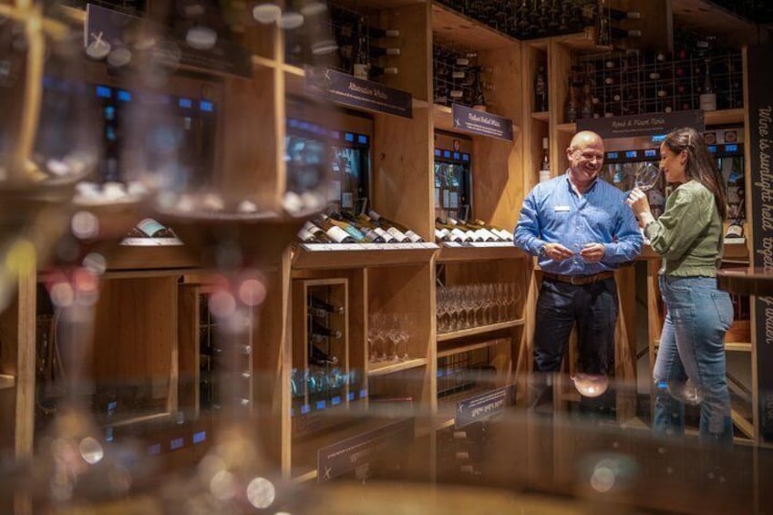 A wine store with wooden shelves and wine bottles. 2