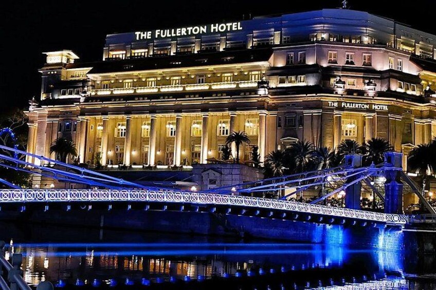 El Hotel Fullerton de noche, con arquitectura iluminada y un puente en primer plano. 5