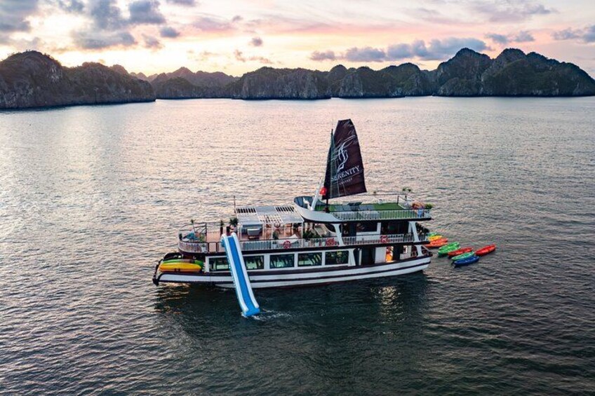 A boat with a flag, docked near a calm body of water with mountains in the background. 2