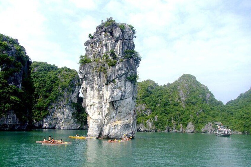 A rock formation surrounded by water with people kayaking. 3