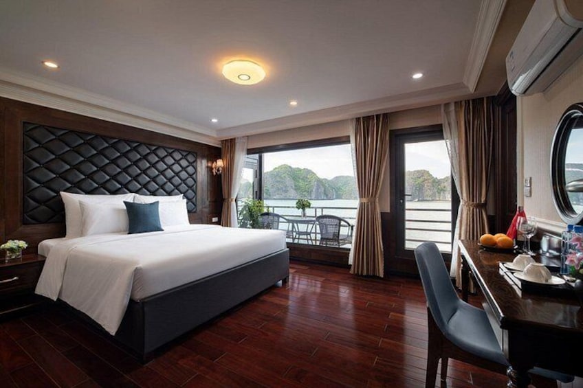 A modern hotel room with a large bed, a dining area, and a view of the outdoors. 4