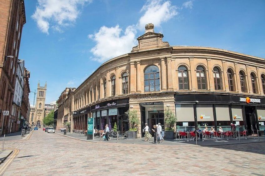 A historic building with arched windows and a clock tower in the background. 2