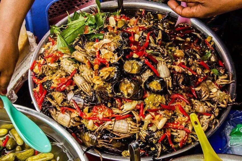 Une grande poêle en métal remplie de fruits de mer, notamment de crabes et de moules, et agrémentée de piments rouges. 3