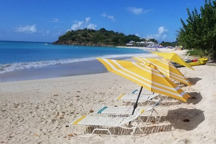 A beach with yellow umbrellas and lounge chairs. 3